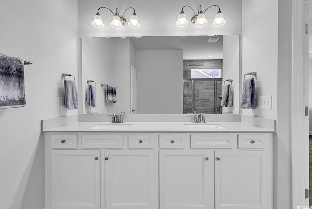 bathroom with double vanity, a sink, and a stall shower