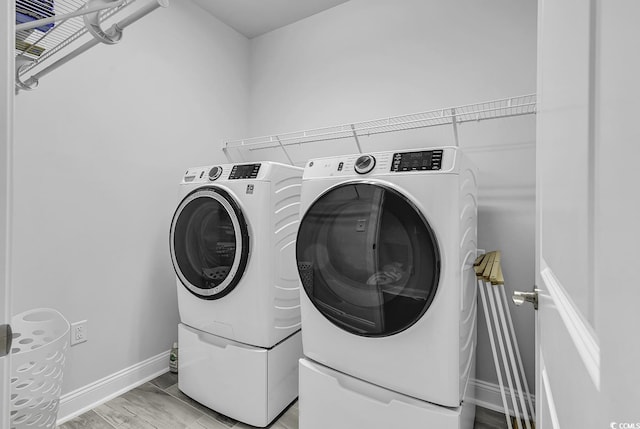laundry area featuring laundry area, baseboards, and washing machine and clothes dryer
