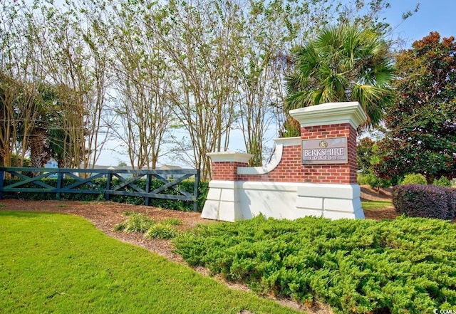 community sign with a lawn and fence