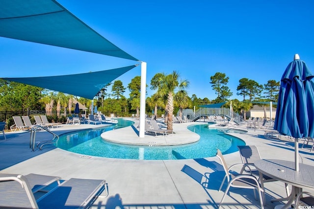 community pool with fence and a patio