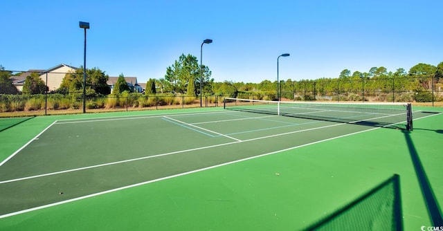 view of tennis court with fence and community basketball court