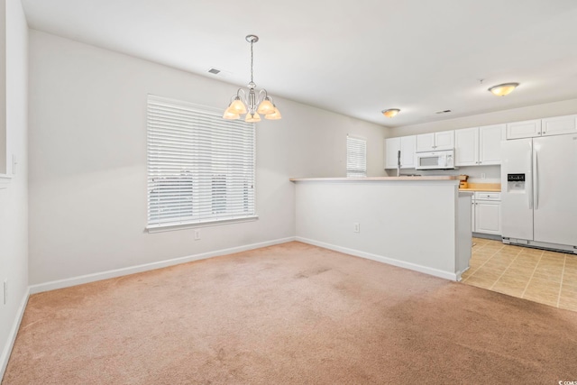 138 Butkus Dr Unit 2, Myrtle Beach, SC 29588 - kitchen with decorative light fixtures, light colored carpet, white cabinets, a notable chandelier, and white appliances