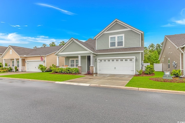 craftsman-style house with a shingled roof, an attached garage, board and batten siding, a front yard, and driveway
