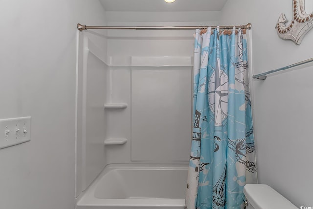 bathroom featuring shower / bath combo and toilet
