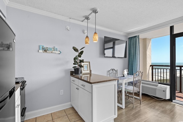 6900 N Ocean Blvd Unit 1105, Myrtle Beach, SC 29572 - kitchen featuring stainless steel fridge, gas stove, white cabinets, a textured ceiling, and ornamental molding