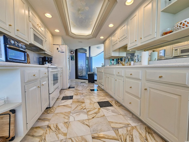 kitchen with white microwave, light countertops, white cabinetry, and recessed lighting
