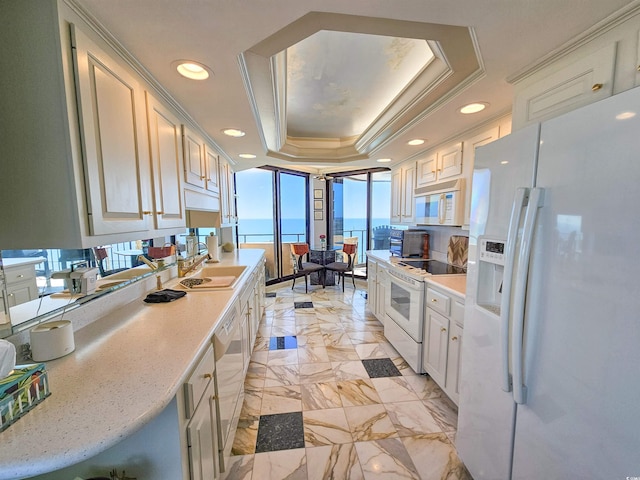 kitchen with white appliances, a sink, light countertops, light marble finish floors, and recessed lighting
