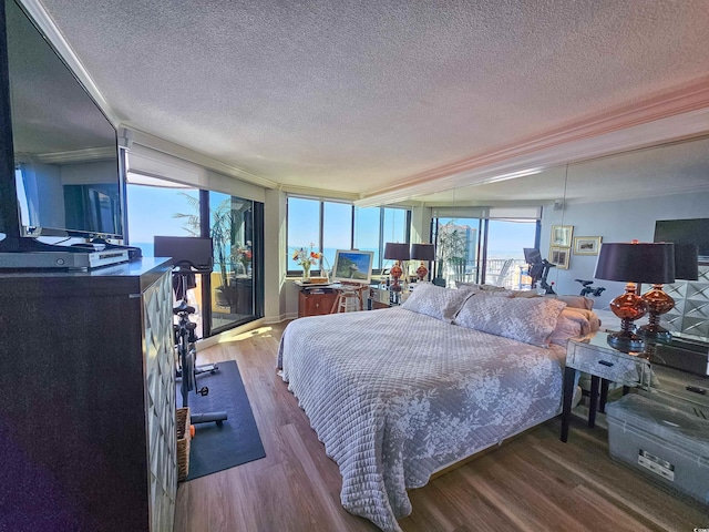 bedroom featuring a textured ceiling, wood finished floors, and crown molding