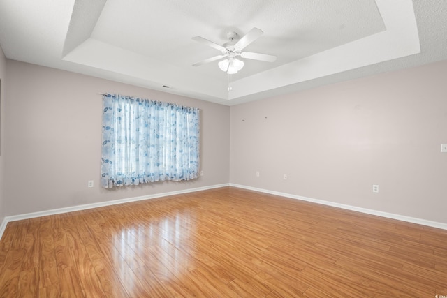5107 Capulet Cir, Myrtle Beach, SC 29588 - unfurnished room with a tray ceiling, light wood-style floors, baseboards, and ceiling fan