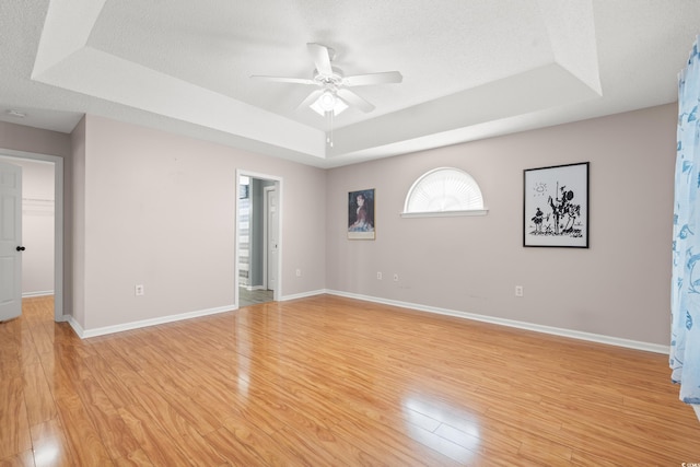 5107 Capulet Cir, Myrtle Beach, SC 29588 - spare room with a ceiling fan, a raised ceiling, light wood-style floors, and baseboards