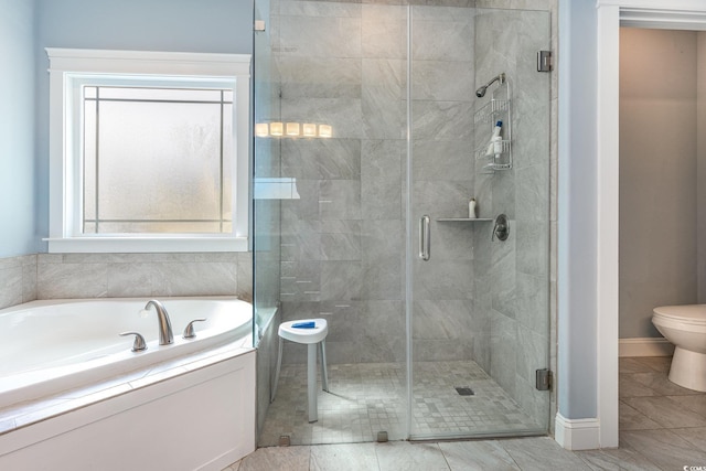 full bath featuring toilet, baseboards, a garden tub, and a stall shower