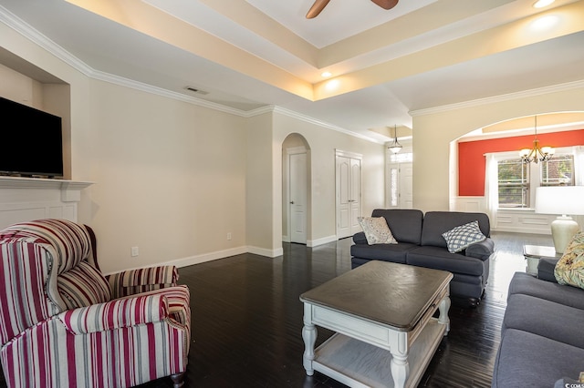 living area with crown molding, arched walkways, dark wood finished floors, a tray ceiling, and visible vents