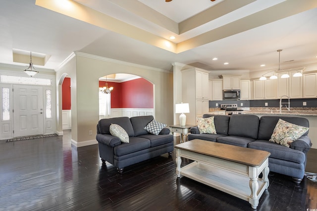 1800 Wood Stork Dr, Conway, SC 29526 - living area featuring arched walkways, dark wood-style flooring, a wainscoted wall, crown molding, and a tray ceiling