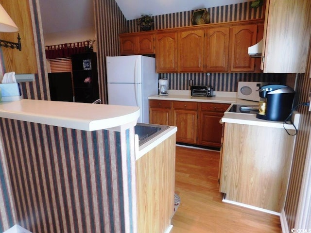 916 Charles St, North Myrtle Beach, SC 29582 - kitchen featuring white appliances, light countertops, ventilation hood, and light wood-style floors