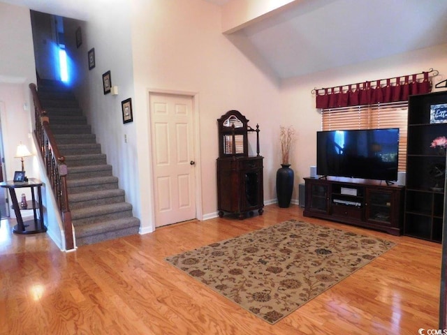 916 Charles St, North Myrtle Beach, SC 29582 - living area with baseboards, high vaulted ceiling, stairs, and wood finished floors