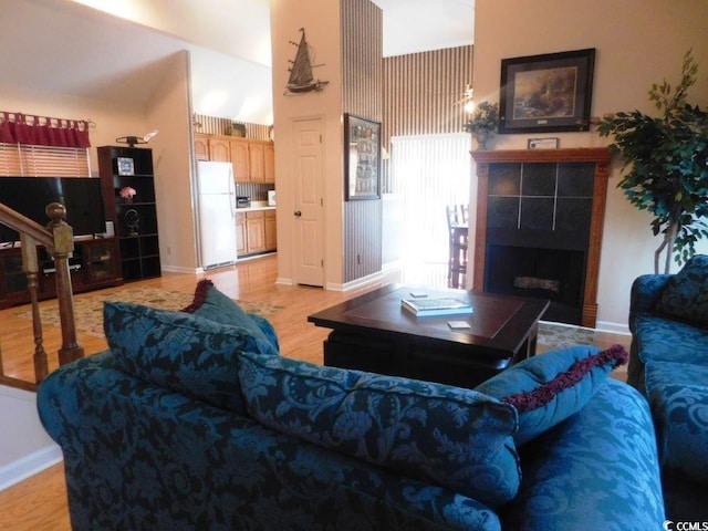 916 Charles St, North Myrtle Beach, SC 29582 - living room with a tiled fireplace, baseboards, and light wood-type flooring