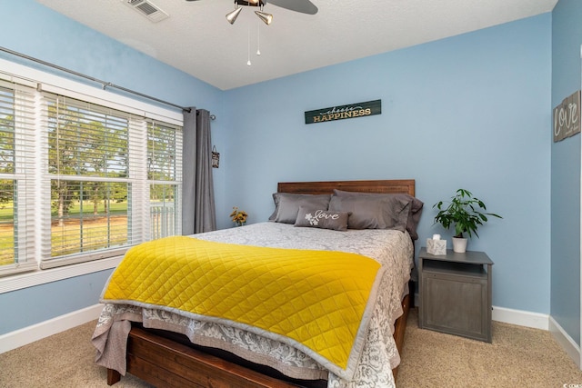 carpeted bedroom with baseboards, visible vents, and ceiling fan