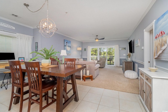 dining room with crown molding, light tile patterned flooring, light carpet, ceiling fan with notable chandelier, and visible vents