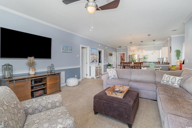 living room with crown molding, light carpet, a ceiling fan, and a textured ceiling