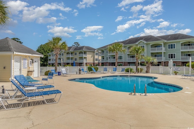 pool featuring fence and a patio area