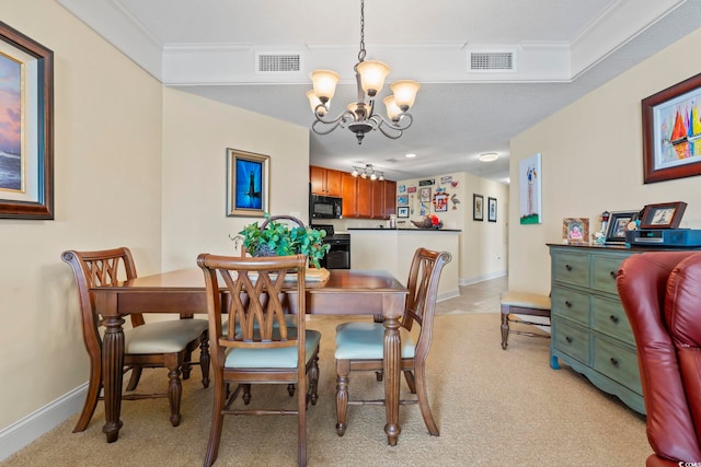 dining room featuring a chandelier, baseboards, visible vents, and light colored carpet