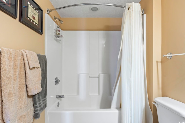 full bath featuring toilet, a textured ceiling, and shower / bath combination with curtain