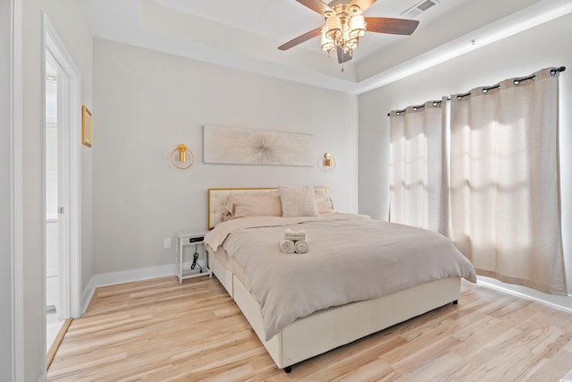 6253 Catalina Dr Unit 1533, North Myrtle Beach, SC 29582 - bedroom featuring light wood-style floors, a tray ceiling, baseboards, and ceiling fan