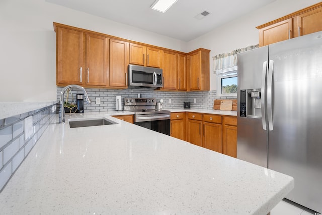 6253 Catalina Dr Unit 1533, North Myrtle Beach, SC 29582 - kitchen featuring stainless steel appliances, a sink, brown cabinets, light stone counters, and backsplash