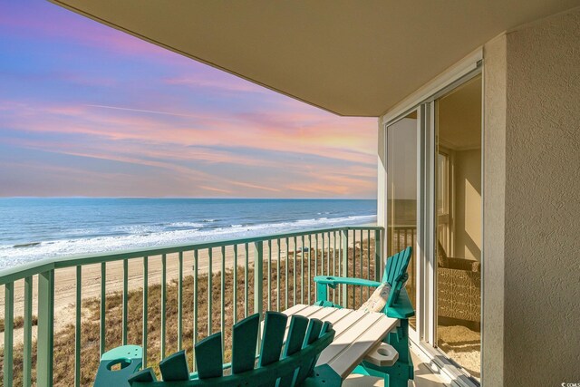 2507 S Ocean Blvd Unit 403, North Myrtle Beach, SC 29582 - balcony at dusk featuring a water view and a view of the beach
