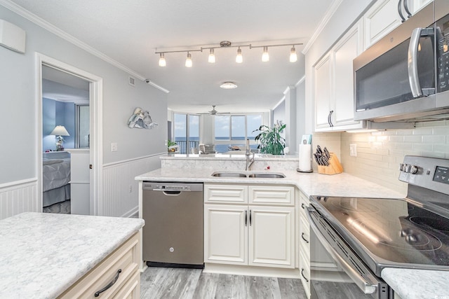2507 S Ocean Blvd Unit 403, North Myrtle Beach, SC 29582 - kitchen featuring light wood finished floors, wainscoting, a sink, white cabinetry, and appliances with stainless steel finishes