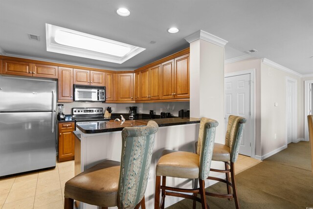 9994 Beach Club Dr Unit 2403, Myrtle Beach, SC 29572 - kitchen with stainless steel appliances, ornamental molding, dark countertops, a kitchen breakfast bar, and brown cabinetry
