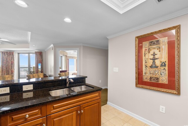 9994 Beach Club Dr Unit 2403, Myrtle Beach, SC 29572 - kitchen featuring a sink, dark stone countertops, baseboards, ornamental molding, and brown cabinetry