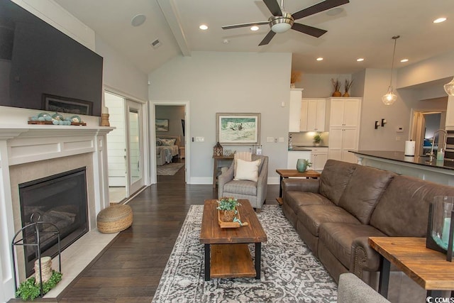 living area featuring a fireplace with flush hearth, wood finished floors, beamed ceiling, recessed lighting, and a ceiling fan