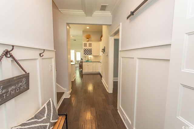 corridor featuring crown molding, dark wood-type flooring, and visible vents