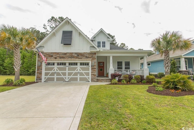 craftsman-style house featuring covered porch, board and batten siding, concrete driveway, and a front yard