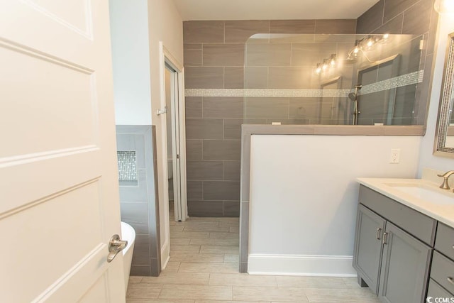 full bath featuring a walk in shower, wood finish floors, and vanity