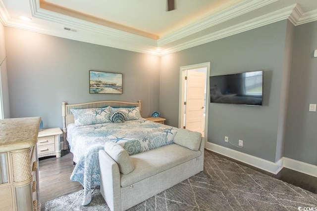 bedroom featuring crown molding, dark wood-style flooring, visible vents, and a raised ceiling