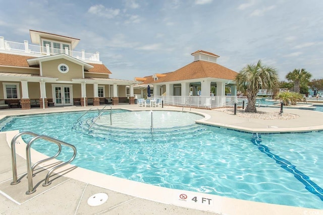 pool with a patio, fence, and french doors