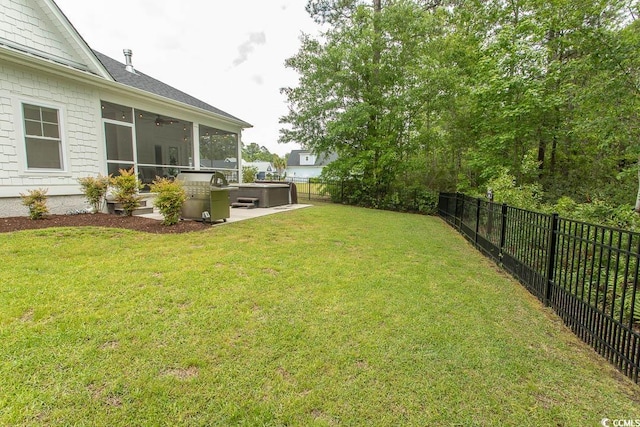 view of yard featuring a fenced backyard, a sunroom, a ceiling fan, and a hot tub
