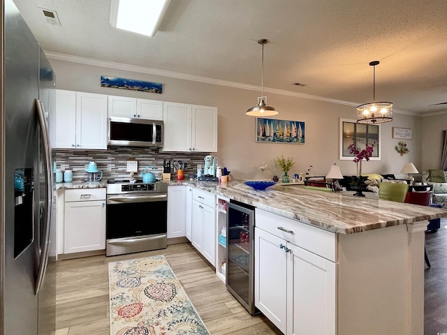 3979 Forsythia Ct Unit 203, Myrtle Beach, SC 29588 - kitchen with appliances with stainless steel finishes, beverage cooler, a peninsula, ornamental molding, and white cabinets