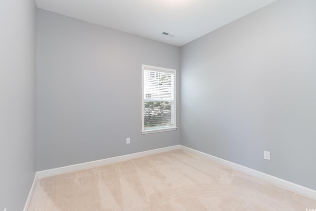 empty room featuring light carpet and baseboards