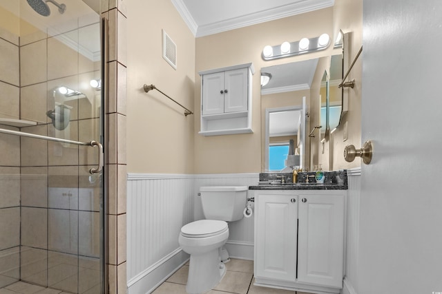 bathroom featuring visible vents, crown molding, wainscoting, a stall shower, and toilet