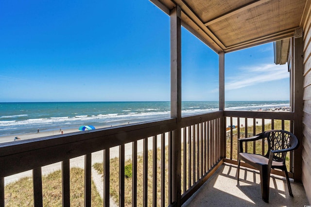 balcony featuring a water view and a view of the beach
