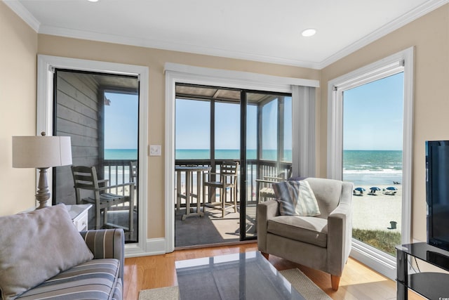 living room with a water view, ornamental molding, recessed lighting, and light wood-style flooring