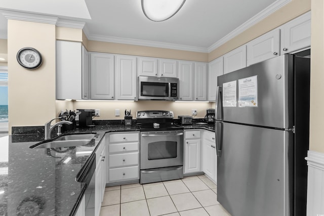 kitchen featuring crown molding, white cabinets, appliances with stainless steel finishes, a sink, and light tile patterned floors