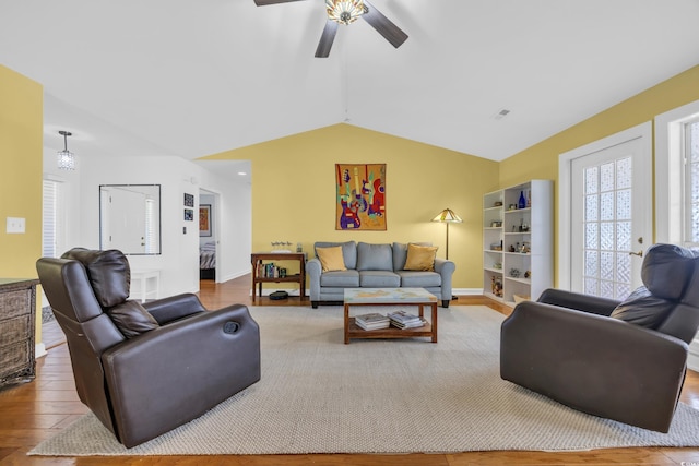 living room with lofted ceiling, visible vents, ceiling fan, and wood finished floors