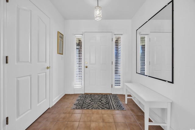 foyer with light tile patterned flooring and baseboards