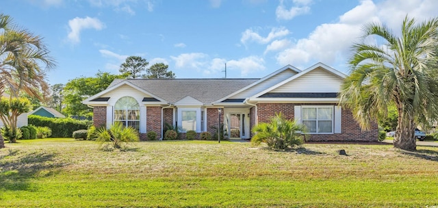 ranch-style house featuring a shingled roof, brick siding, and a front yard