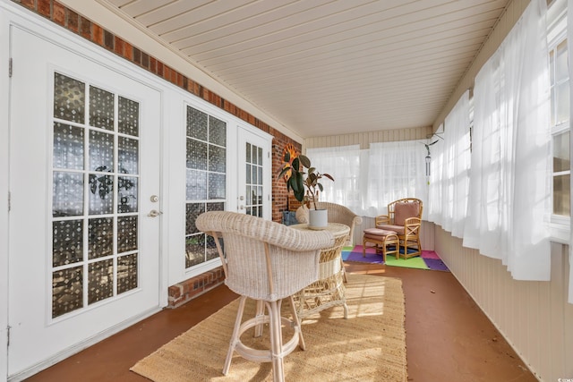 sunroom featuring french doors and finished concrete floors