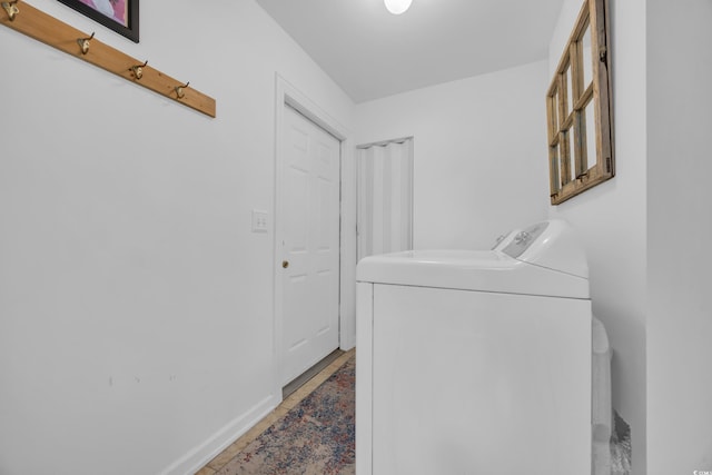 laundry room featuring laundry area, baseboards, and washing machine and dryer